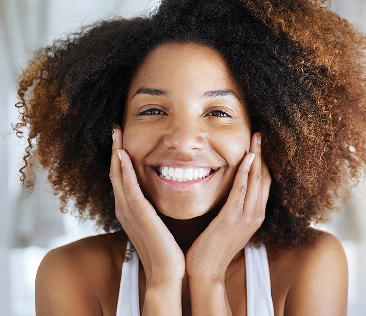 woman smiling and holding face