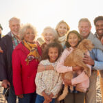 family-friendly dental tips, multigenerational family smiling on the beach in winter