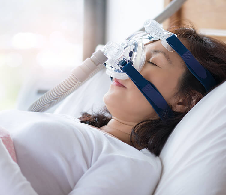 sleeping woman wearing a CPAP mask