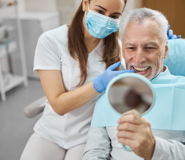 man at the dentist smiling in mirror