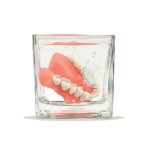 dentures soaking in a glass of water, denture care