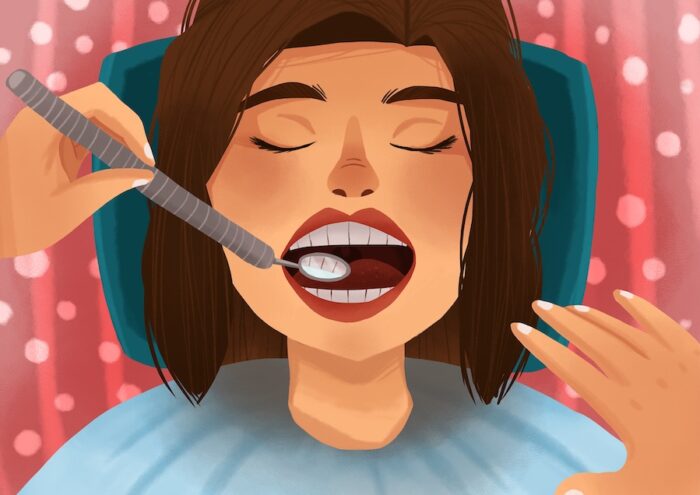 woman getting dental cleaning and exam at the dentist