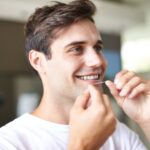 man flossing to reduce bleeding gums