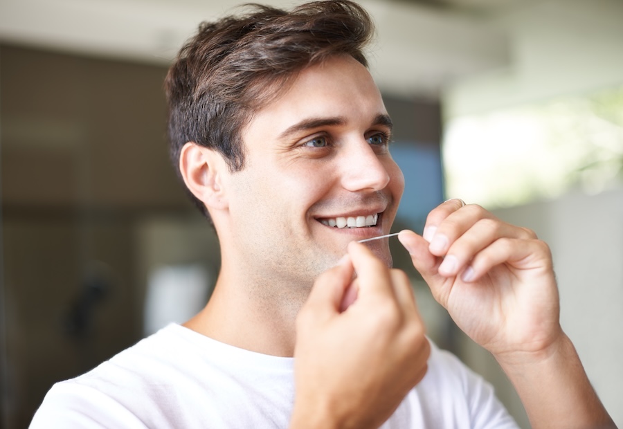 man flossing to reduce bleeding gums
